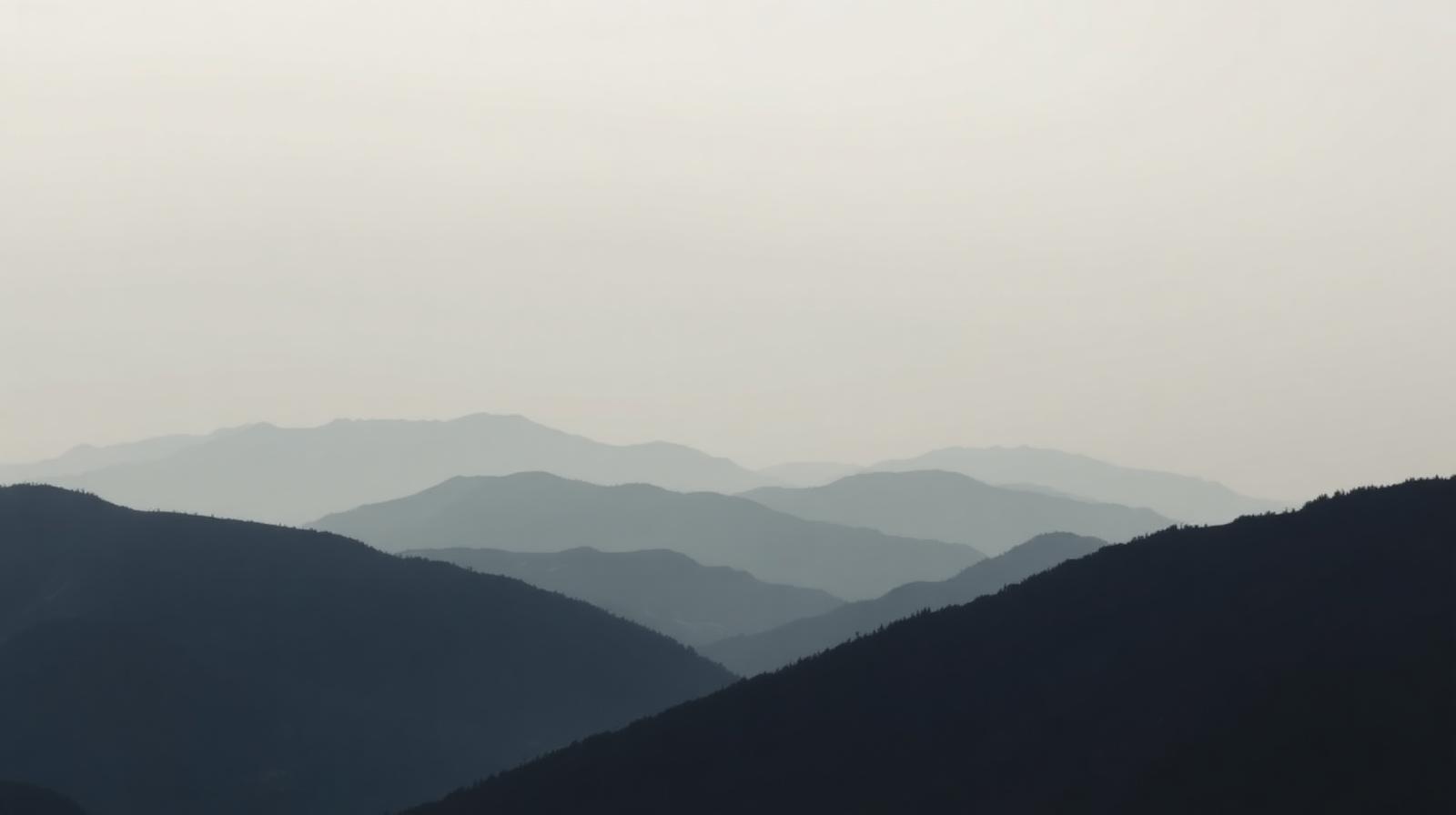 Layered mountain ridges fading into atmospheric haze